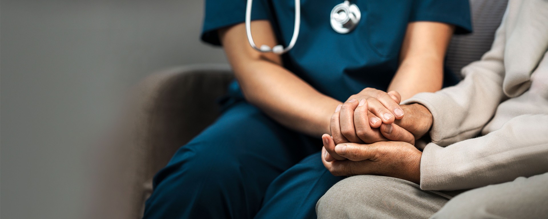 A female nurse caregiver holds hands to encourage and comfort an elderly woman. For care and trust in nursing homes for people of retirement age Caregiver helping elderly woman provides medical advice